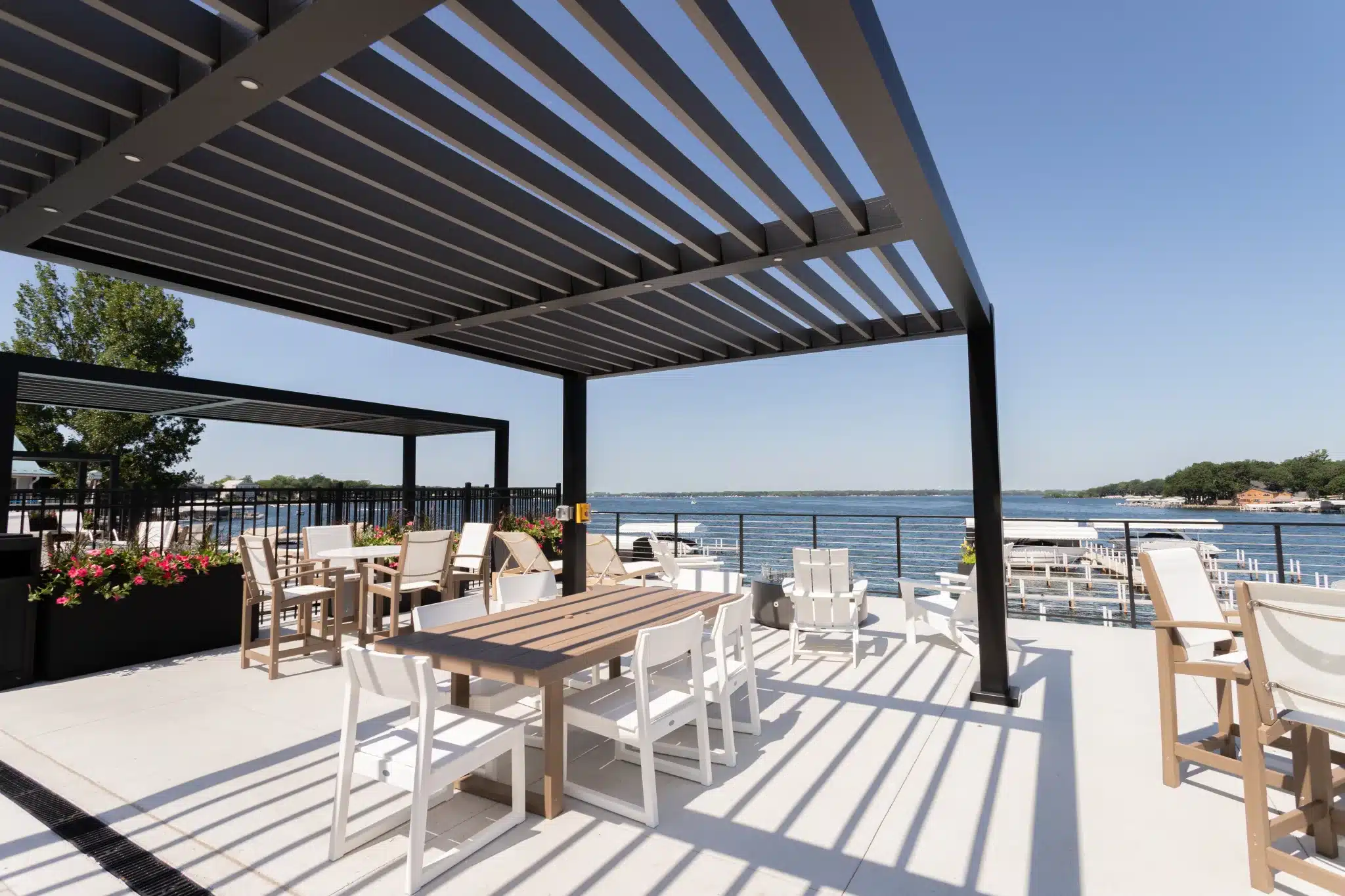 LUXA louvered pergolas over a lakeside dining terrace in South Florida
